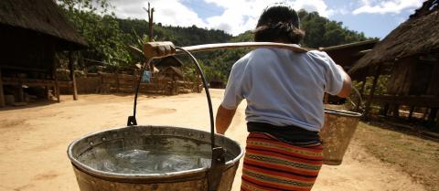 Woman carrying water in Laos