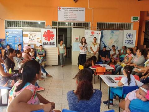 Sr. Roselei Bertoldo holds the microphone and speaks to a group a women about sexual abuse, exploitation, and human trafficking