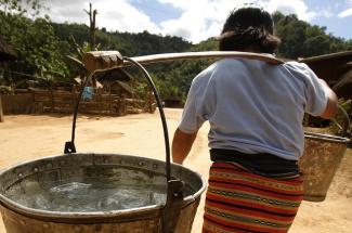 Woman carrying water in Laos