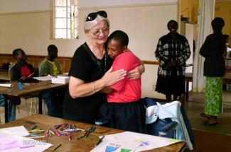 Maryknoll Sister Mary Frances Kobets (left) hugs a student in Zimbabwe