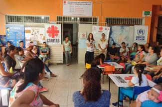 Sr. Roselei Bertoldo holds the microphone and speaks to a group a women about sexual abuse, exploitation, and human trafficking